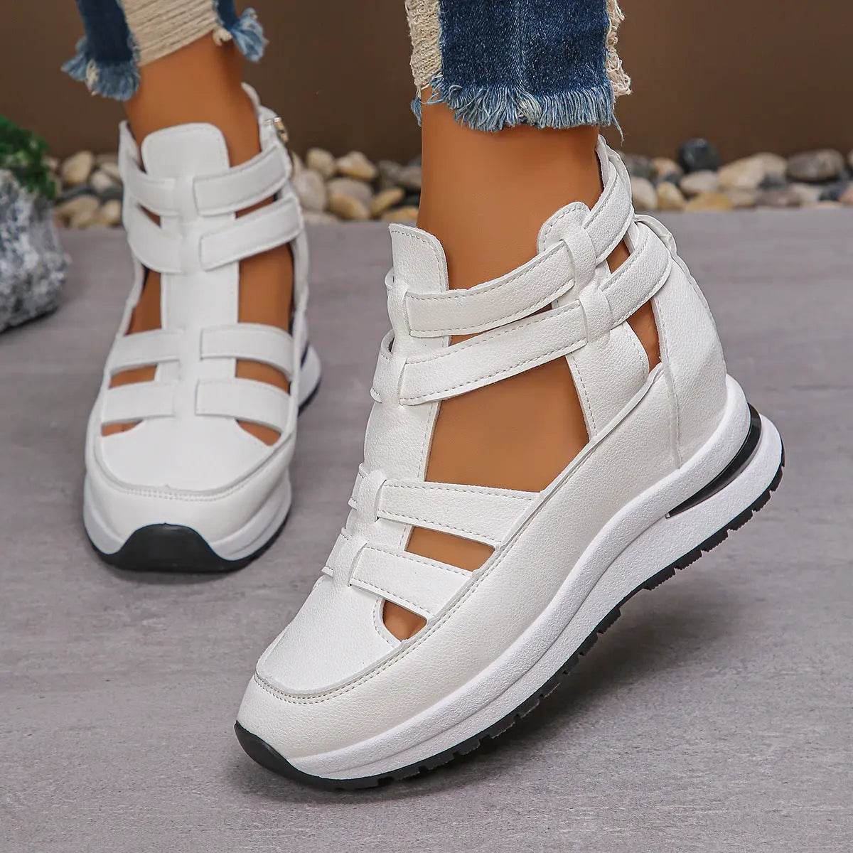 White women's close-toed hollow-out platform sandals with Velcro straps and rubber soles worn with frayed hem jeans