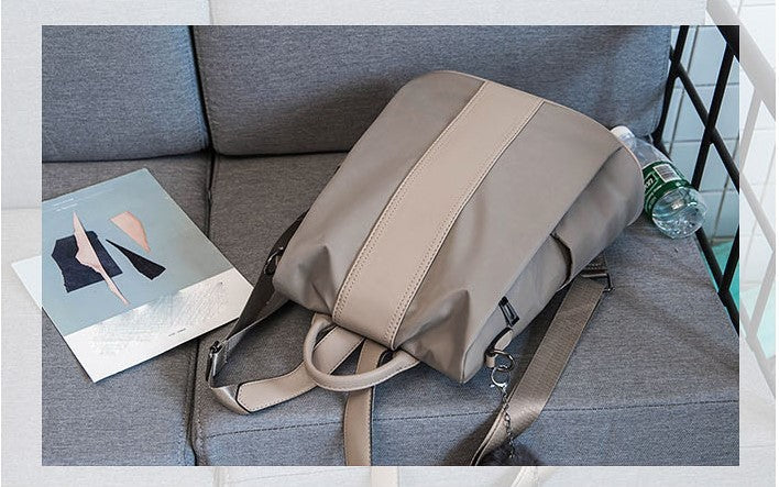 Sheepskin patchwork mini chain shoulder bag in neutral tones on gray couch with abstract art and water bottle nearby