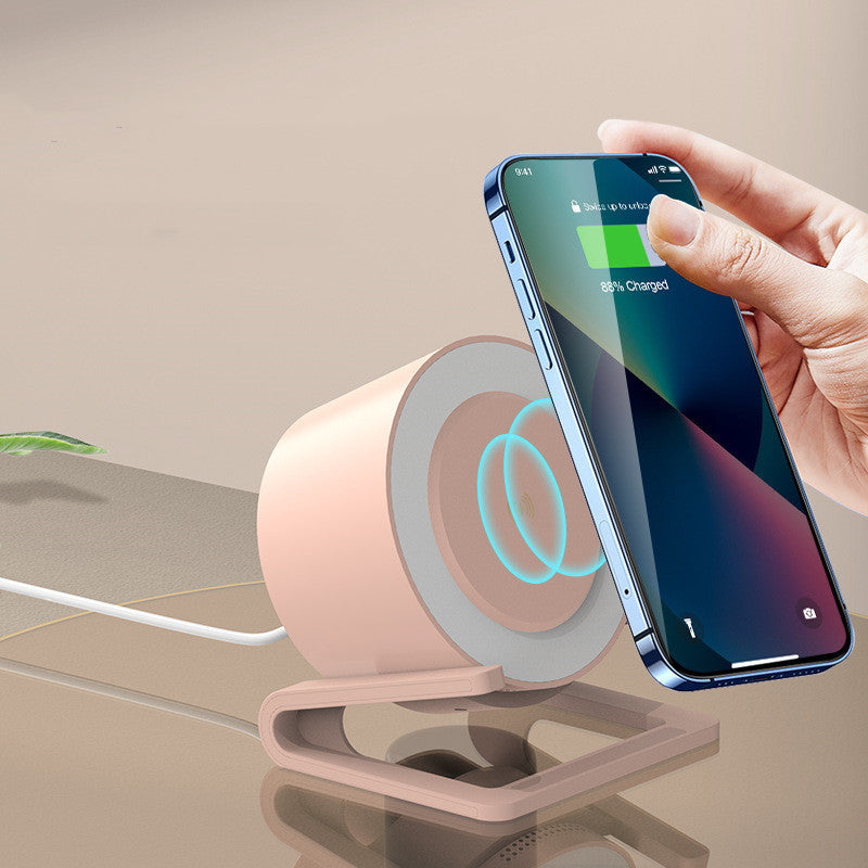 White Bluetooth speaker with wireless charging and Type-C interface next to smartphone charging wirelessly