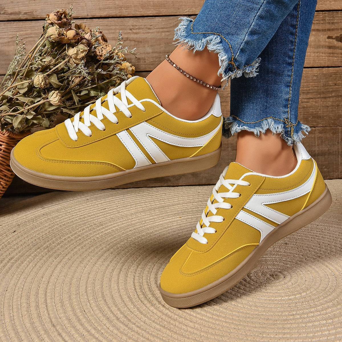 Yellow lace-up round toe flats shoes for women with white accents and casual sporty design