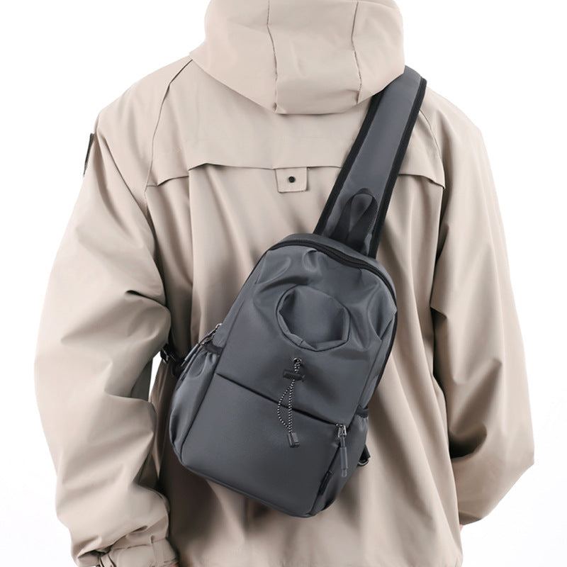 Black Oxford cloth kettle bag worn as a waterproof, breathable, ultra-light crossbody shoulder chest bag for men.