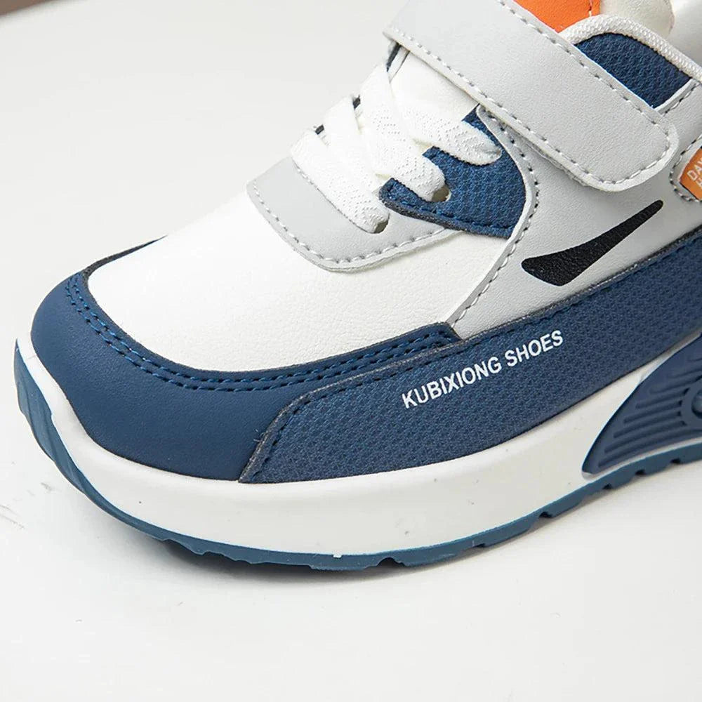 Close-up of children's PU leather sport shoe in white and blue with hook and loop closure and anti-slippery sole